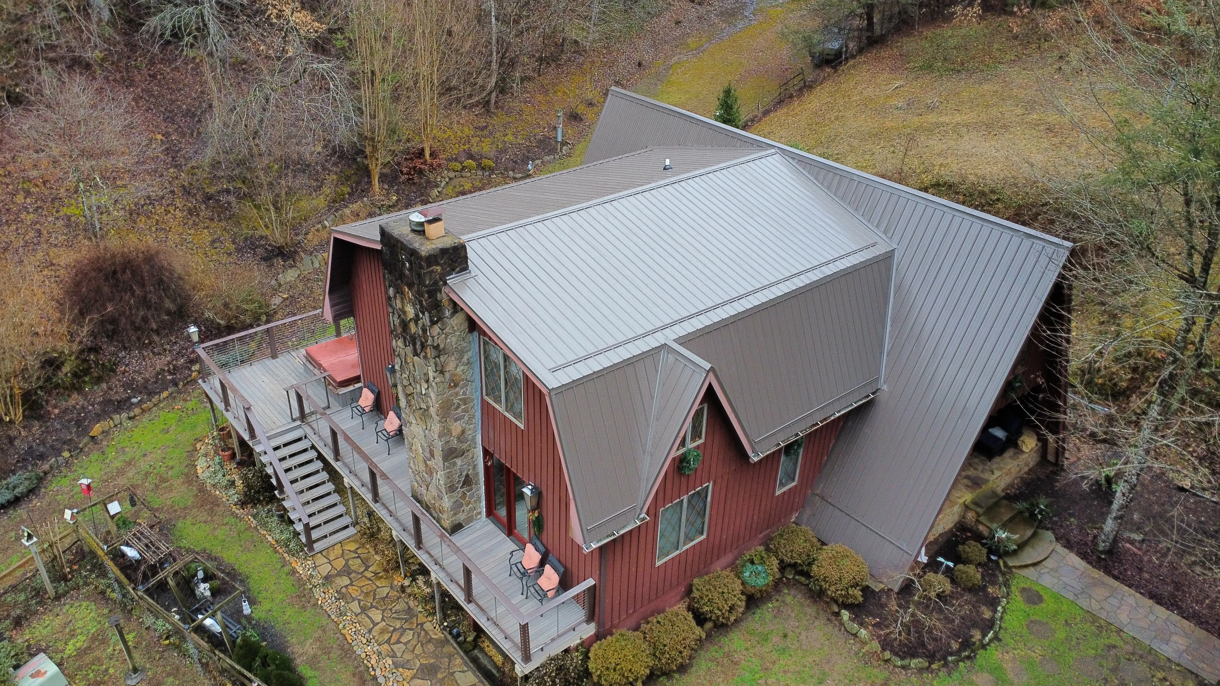 Red-sided cabin with a brown standing-seam metal roof